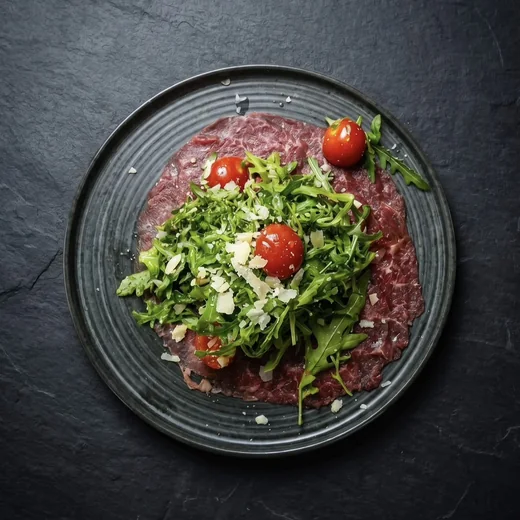 Carpaccio mit Rucola, Kirschtomaten und Parmesan