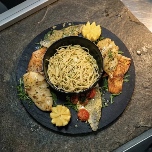 Fischplatte mit Tintenfisch, Lachs und Spaghetti aglio e olio