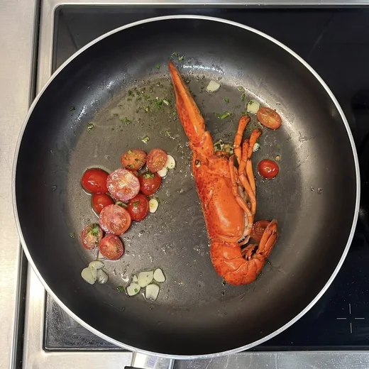 Hummer mit Kirschtomaten und Knoblauch in der Pfanne
